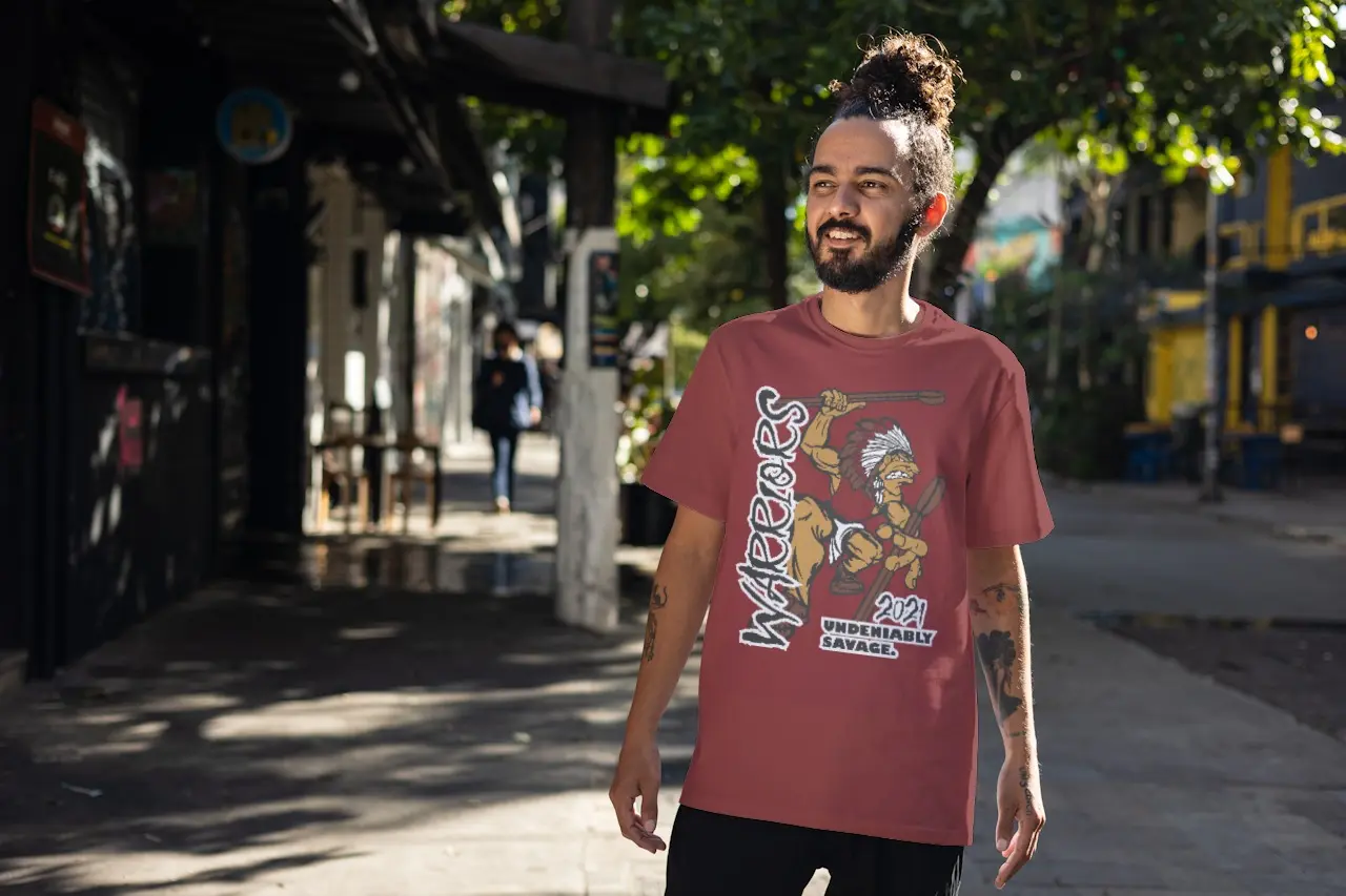 Man with hair in a bun on his head wearing a Warriors fan shirt